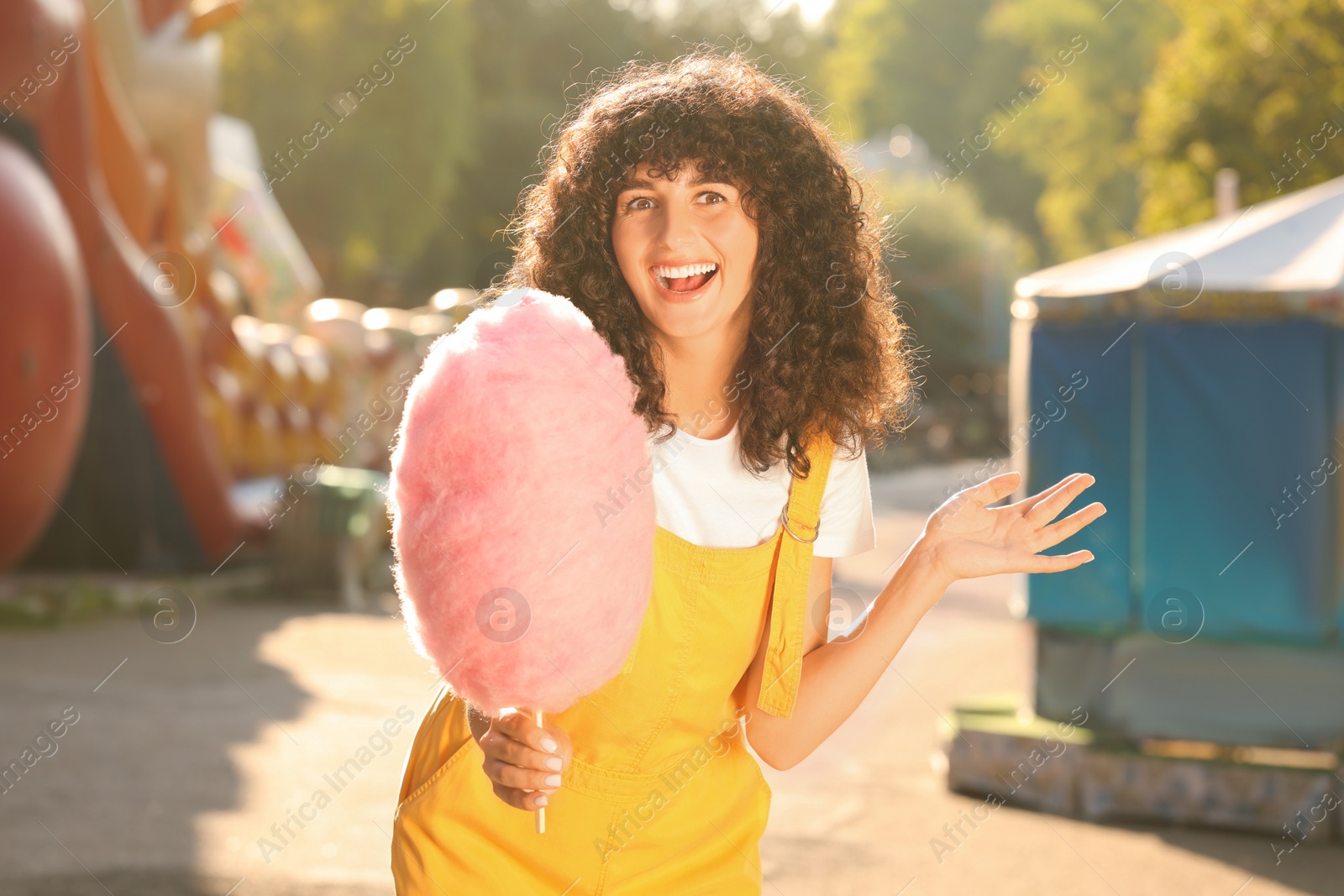 Photo of Portrait of happy woman with cotton candy outdoors on sunny day