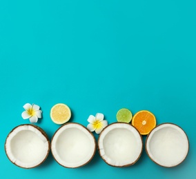 Photo of Flat lay composition with fresh coconut halves on blue background. Space for text