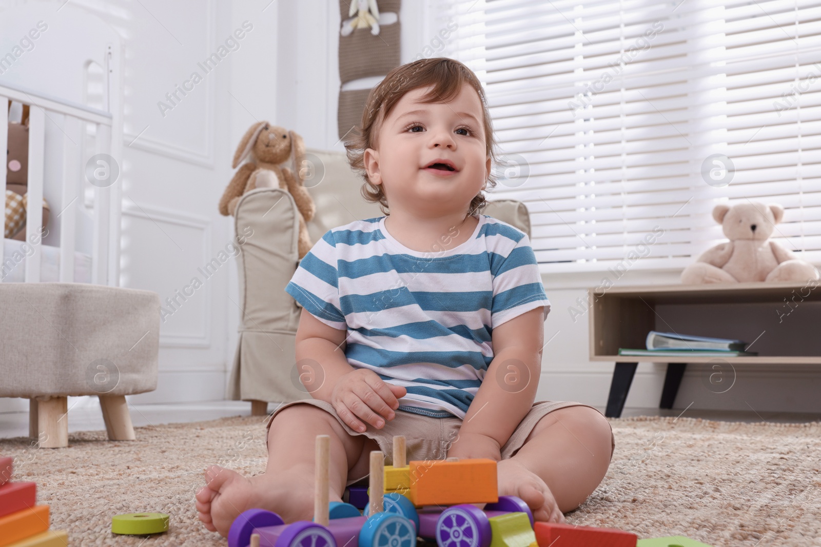 Photo of Cute little boy playing with toys in room at home