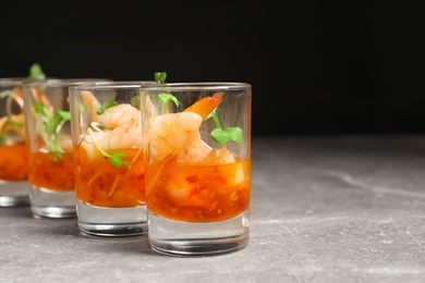 Photo of Delicious shrimp cocktail shots on grey table