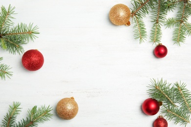 Photo of Flat lay composition with Christmas tree branches and festive decor on wooden background