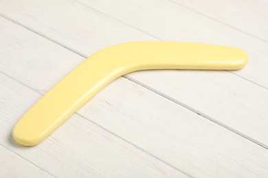 Yellow boomerang on white wooden background. Outdoors activity