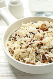 Delicious rice pilaf with mushrooms on white wooden table, closeup