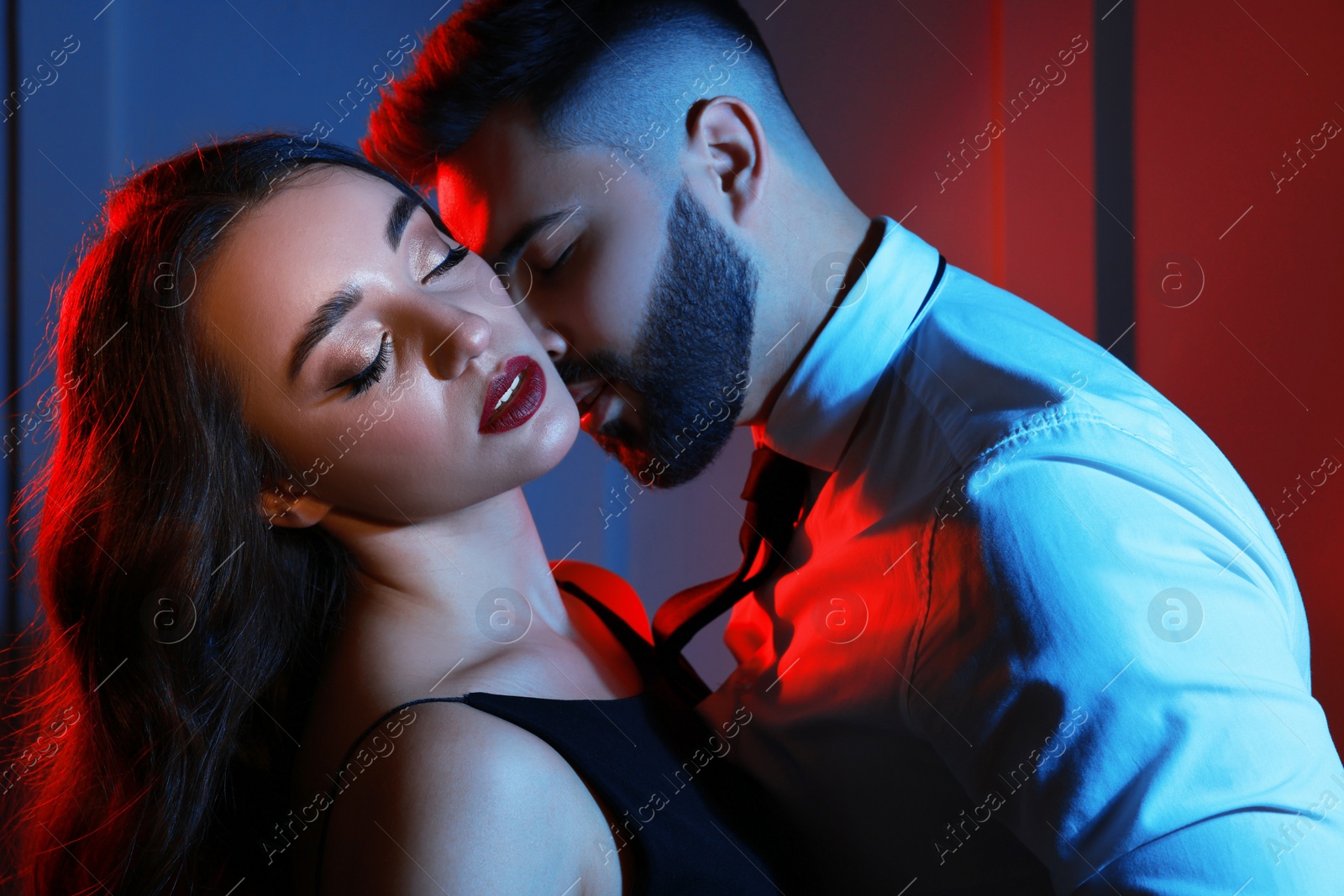 Photo of Handsome bearded man with sexy lady indoors. Color toned