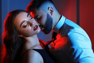 Photo of Handsome bearded man with sexy lady indoors. Color toned