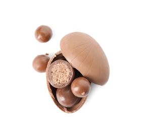 Photo of Broken chocolate Easter egg with candies on white background, top view