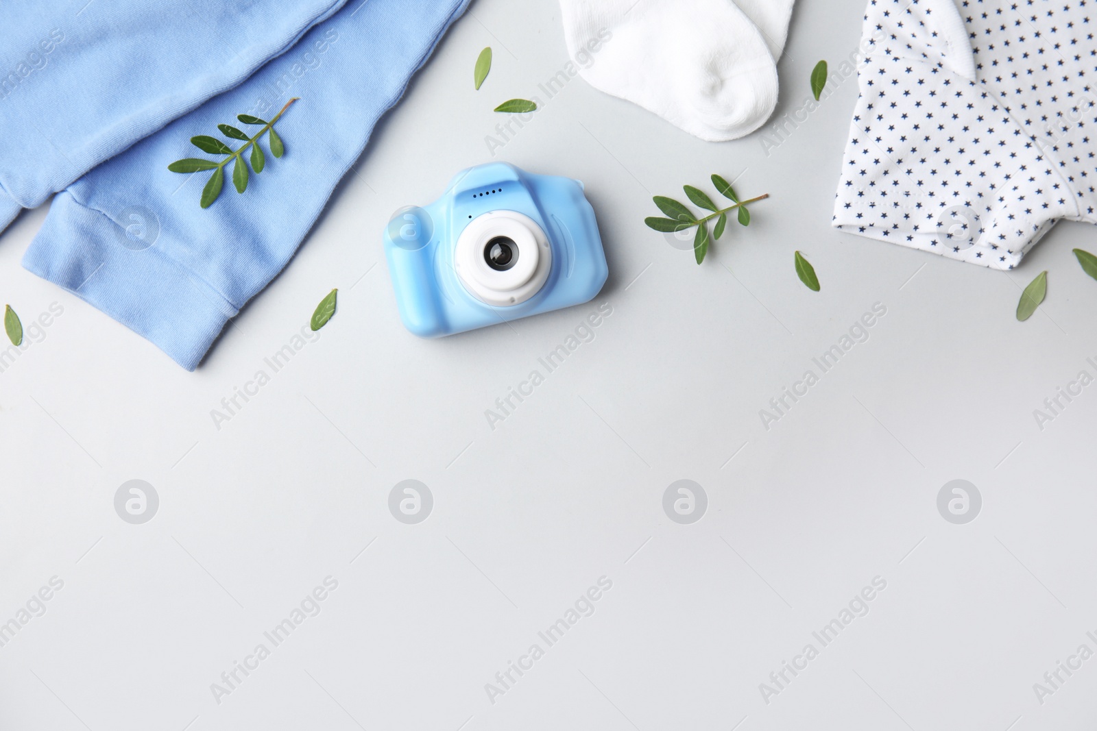 Photo of Flat lay composition with toy camera on light grey background, space for text. Future photographer