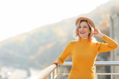Portrait of happy mature woman on balcony, outdoors