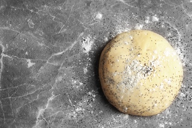 Photo of Raw dough with poppy seeds on table, top view