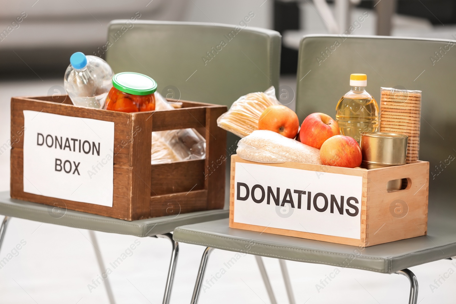 Photo of Donation boxes with food products on chairs indoors