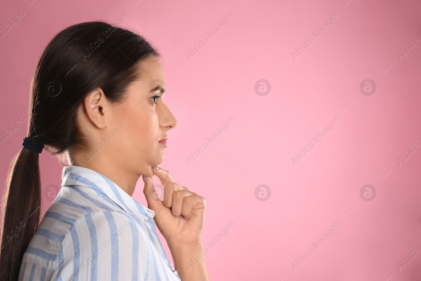Photo of Young woman with double chin on pink background. Space for text
