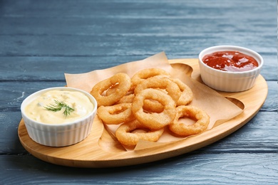 Photo of Fried onion rings served with sauces on plate