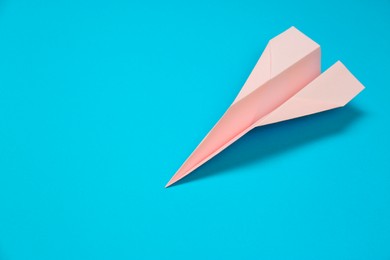 Photo of Paper plane on light blue background, space for text