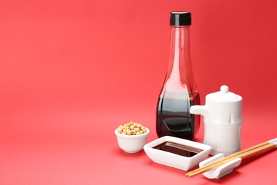 Photo of Tableware with soy sauce and beans on color background. Space for text