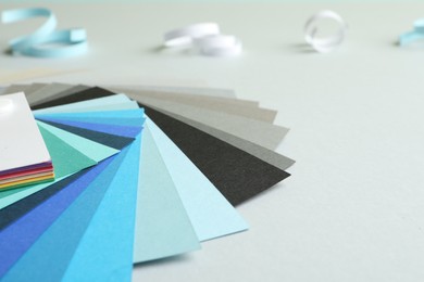 Photo of Color palette and paper curls on white background, closeup