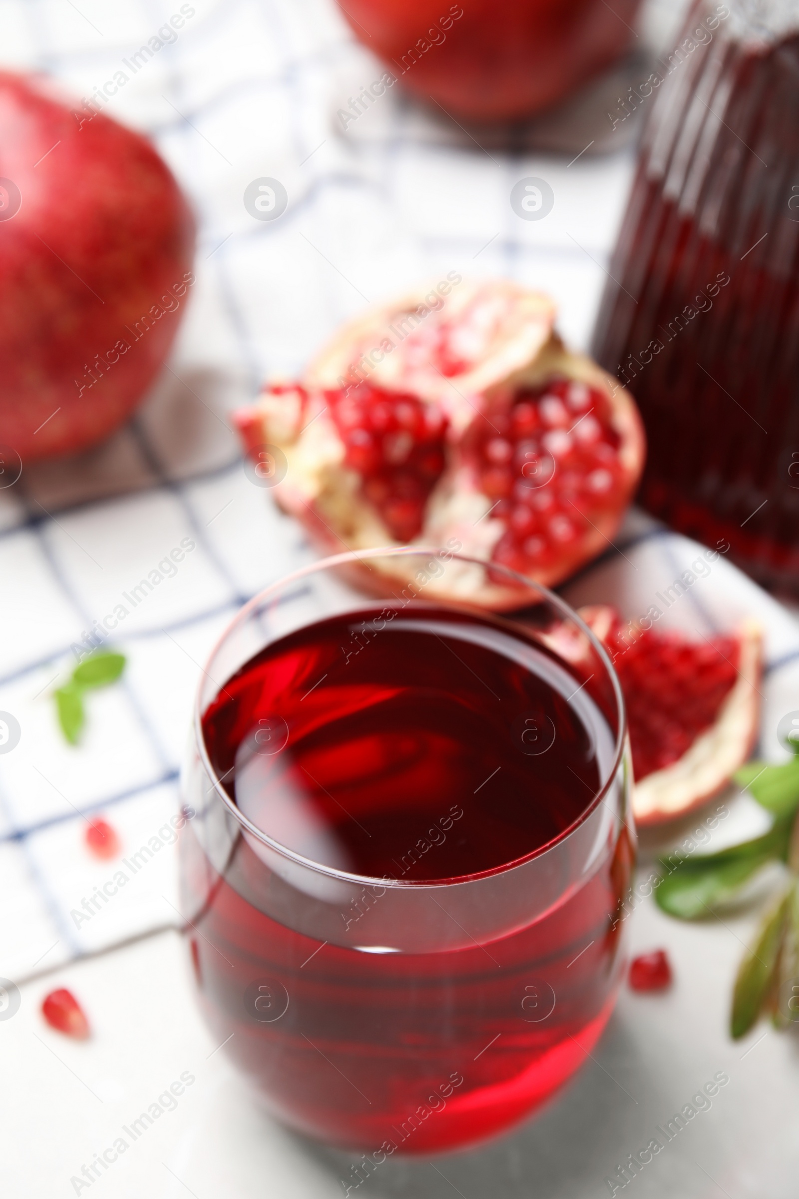 Photo of Glass of pomegranate juice and fresh fruits on white table