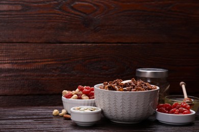 Photo of Tasty granola with nuts, different ingredients on wooden table. Space for text