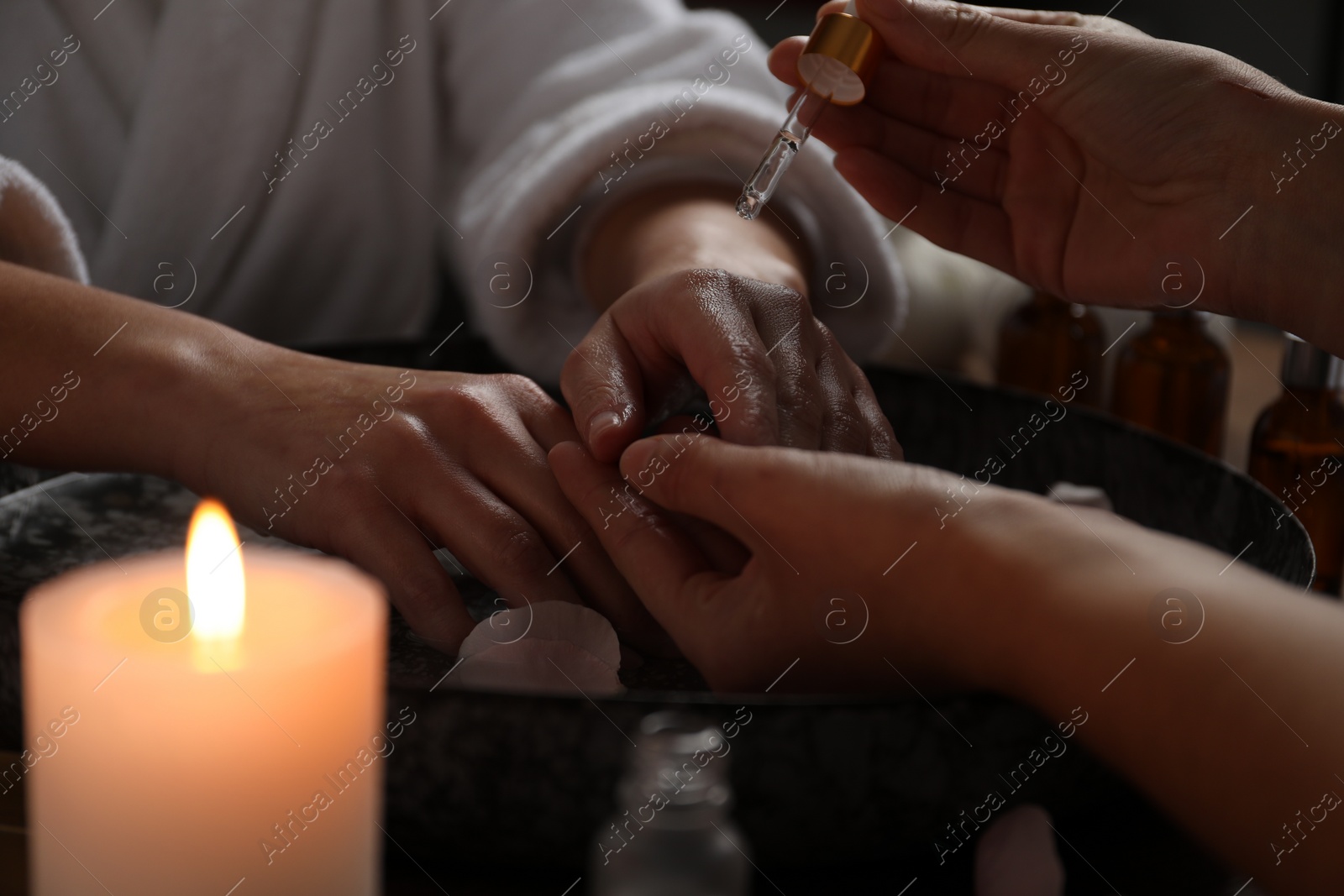 Photo of Woman receiving hand treatment at table in spa, closeup