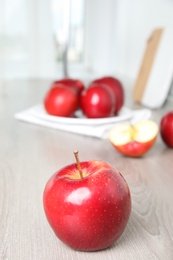 Ripe juicy red apples on white wooden table indoors