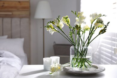 Photo of Beautiful spring freesia flowers on table in bedroom