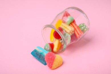 Tasty jelly candies and jar on pink background, closeup