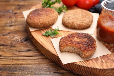 Delicious vegan cutlets on wooden table, closeup. Space for text