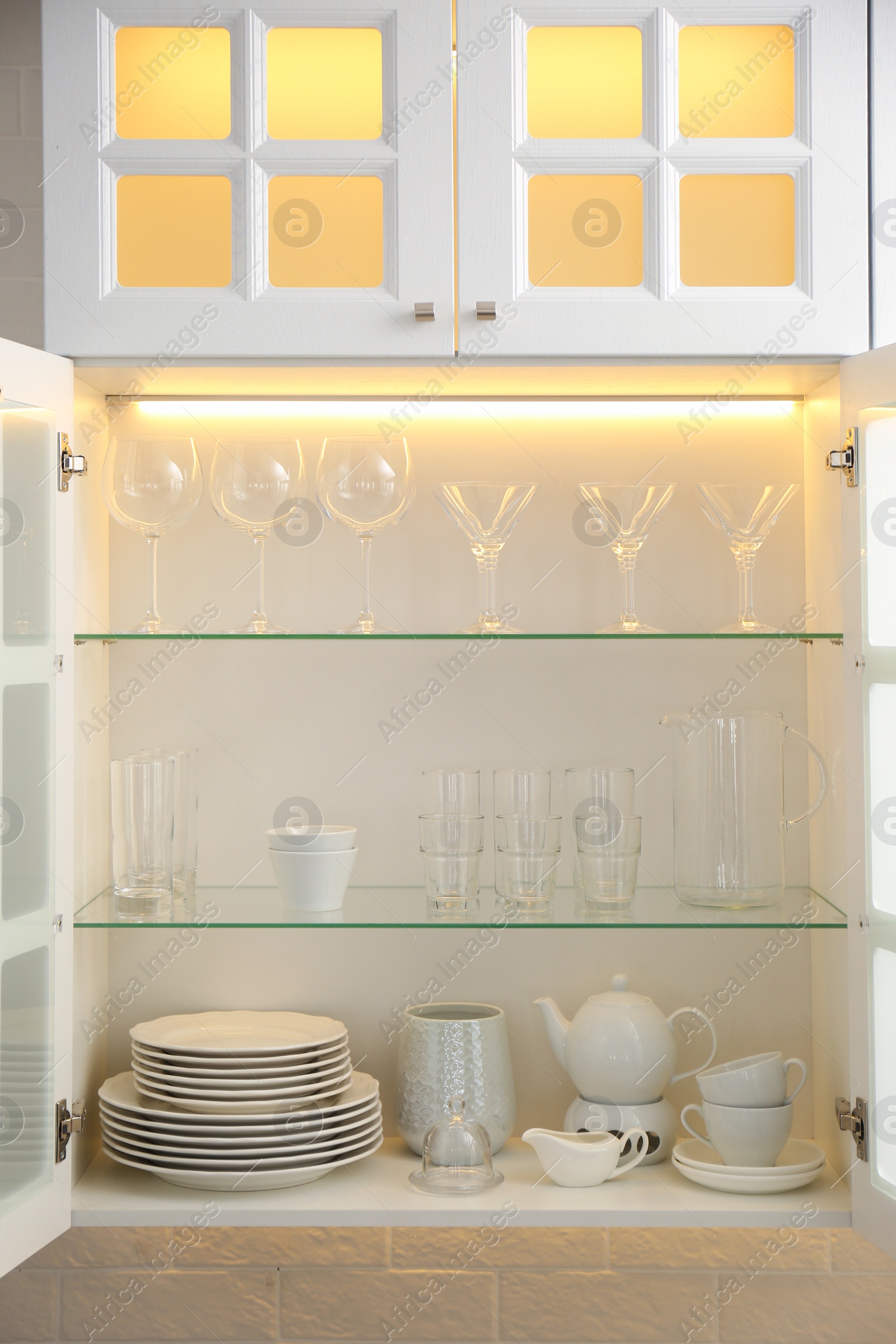 Photo of Cabinet with crockery and glassware. Order in kitchen