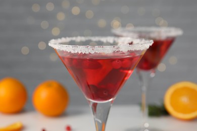 Photo of Tasty cranberry cocktail in glasses on light background, closeup