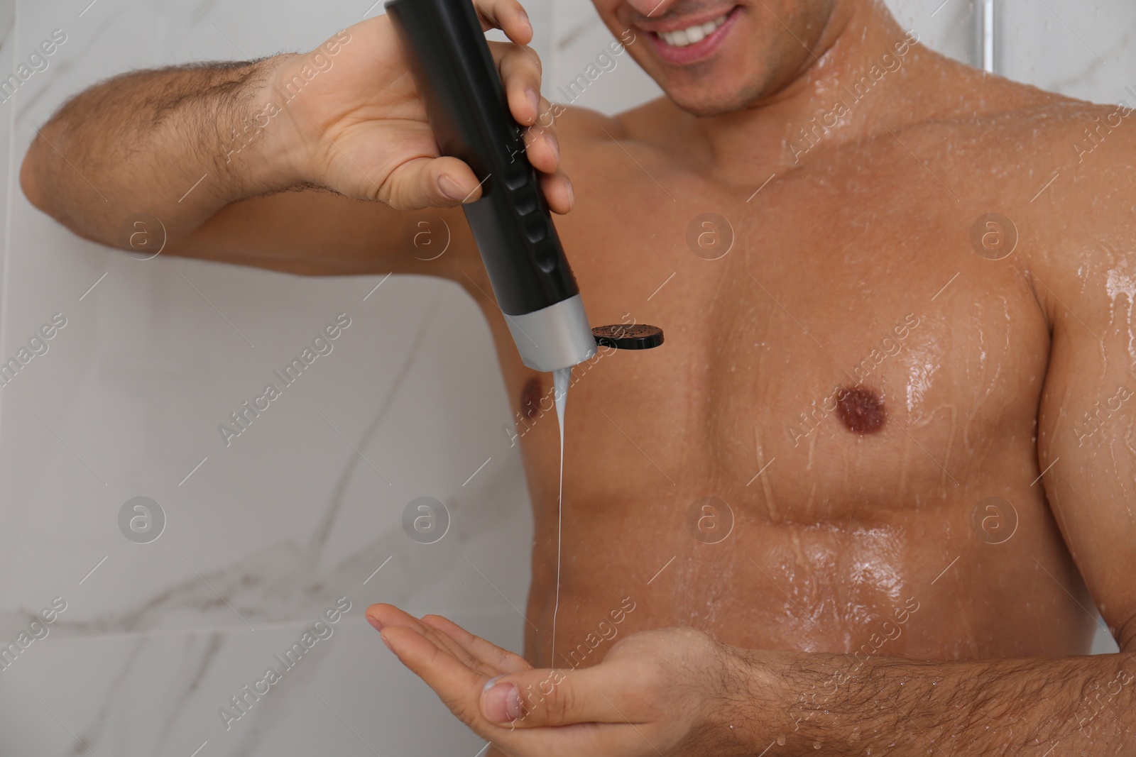 Photo of Man applying gel in shower at home, closeup