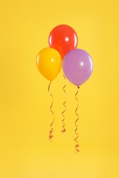 Bright balloons on color background. Celebration time