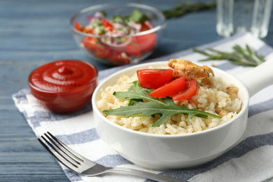 Delicious chicken risotto served in bowl on table