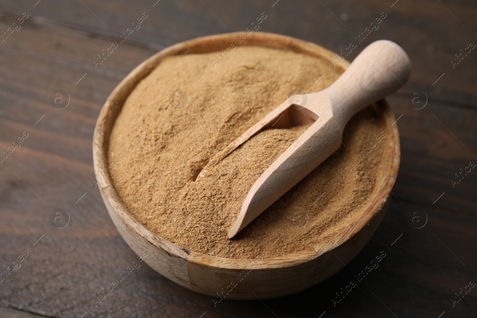 Photo of Dietary fiber. Psyllium husk powder in bowl and scoop on wooden table, closeup