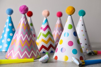 Photo of Birthday party hats and horns on grey table