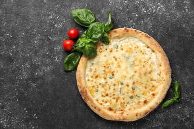 Photo of Delicious cheese pizza, basil and tomatoes on black textured table, flat lay. Space for text