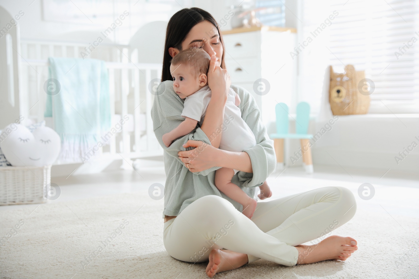 Photo of Young woman with her cute baby at home