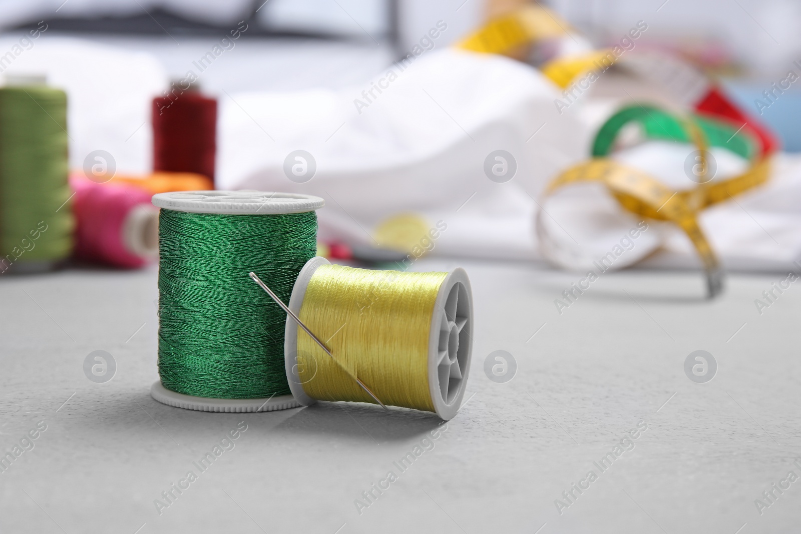 Photo of Bobbins with threads on table. Tailoring accessories