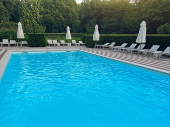 Photo of Outdoor swimming pool in luxury hotel on sunny summer day. Time for relax