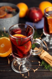 Photo of Tasty mulled wine with spices on wooden table