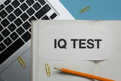 Photo of Note with text IQ Test, notebook, pencil and laptop on light blue background, closeup