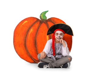 Cute little boy wearing Halloween costume and decorative pumpkin on white background