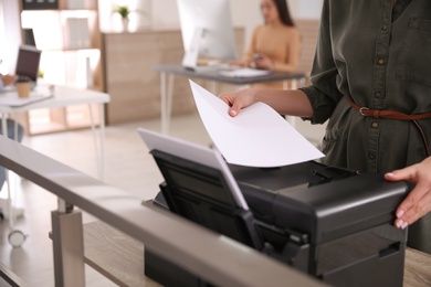 Employee using modern printer in office, closeup