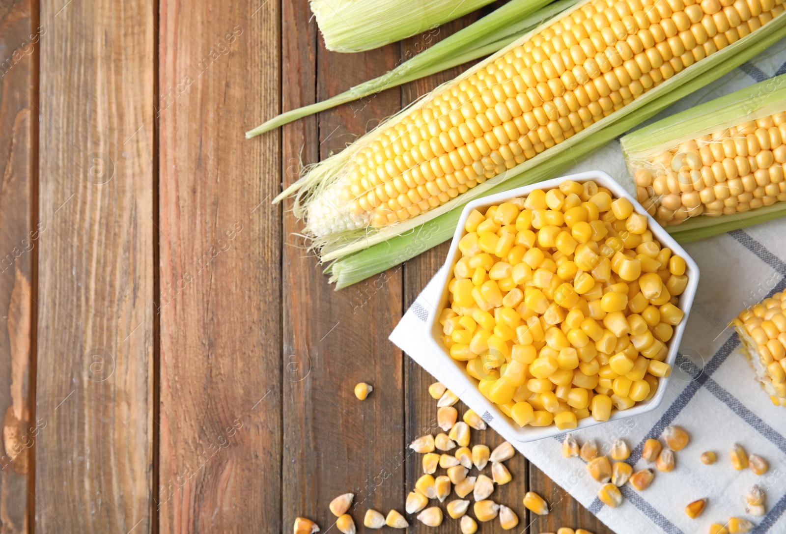 Photo of Flat lay composition with corn kernels on wooden background. Space for text