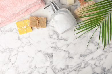 Photo of Flat lay composition with soap dispenser on white marble background. Space for text