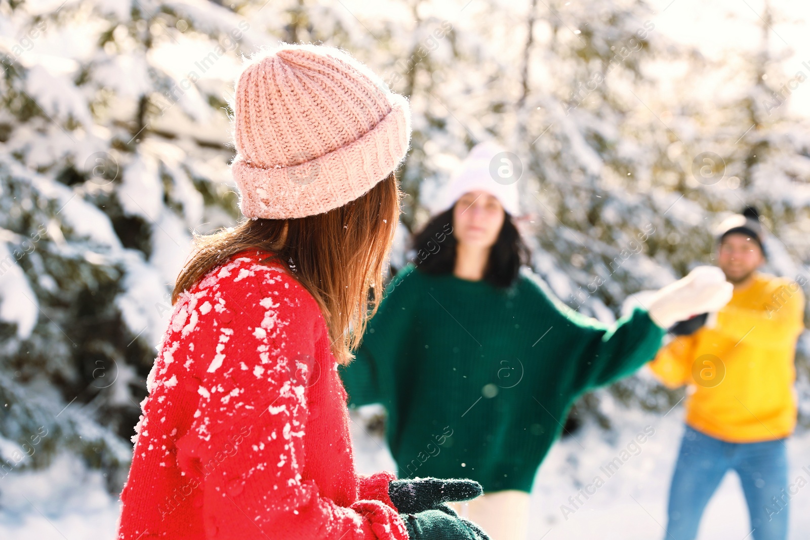 Photo of Group of friends playing snowballs outdoors. Winter vacation