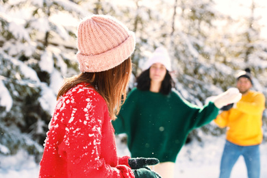 Photo of Group of friends playing snowballs outdoors. Winter vacation