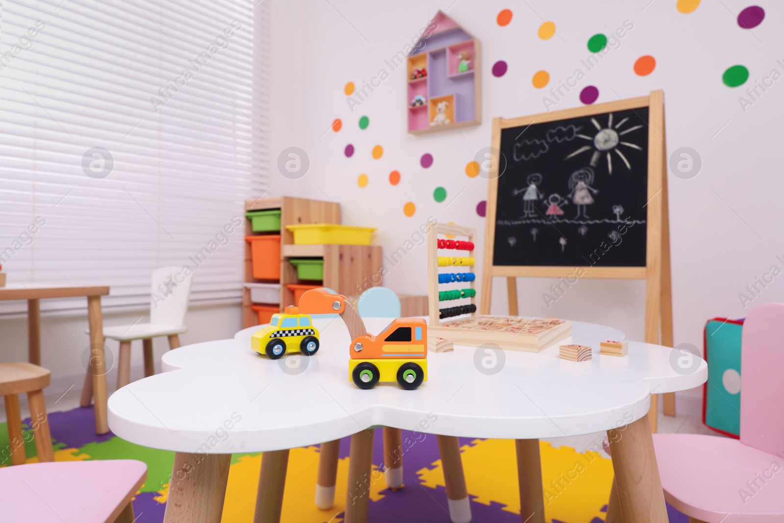 Photo of Stylish kindergarten interior with toys and modern furniture