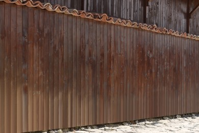 Photo of Shabby wooden fence outdoors on sunny day