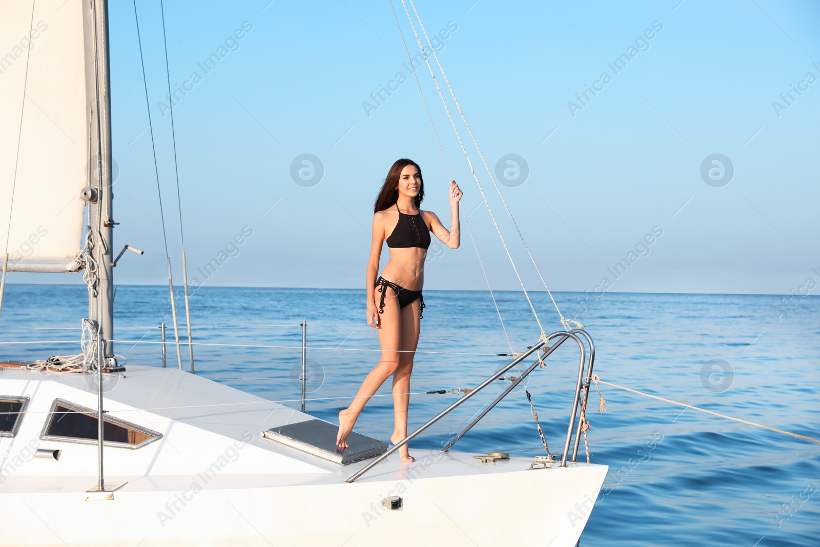 Photo of Beautiful woman in bikini relaxing on yacht during sea trip