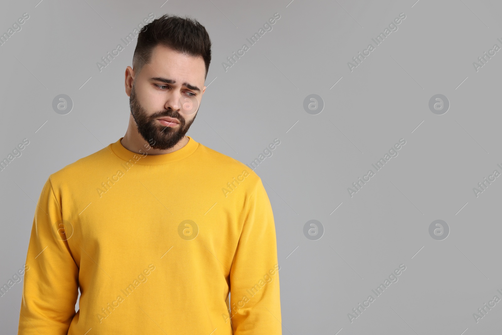 Photo of Portrait of sad man on light grey background, space for text