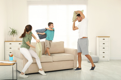 Happy family having pillow fight in living room